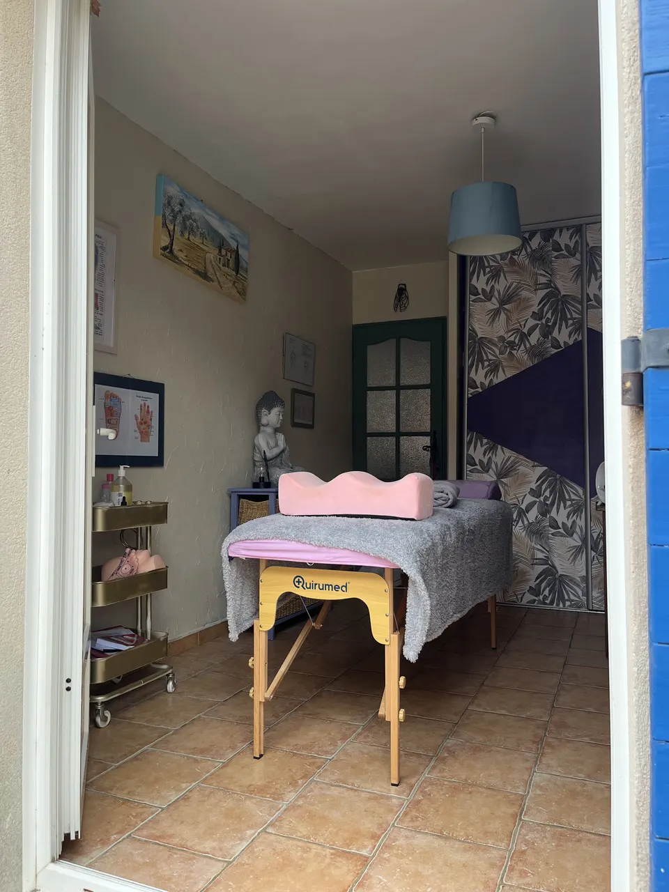 Entrée du cabinet de réflexologie à Tavel, table de soin et coussin rose