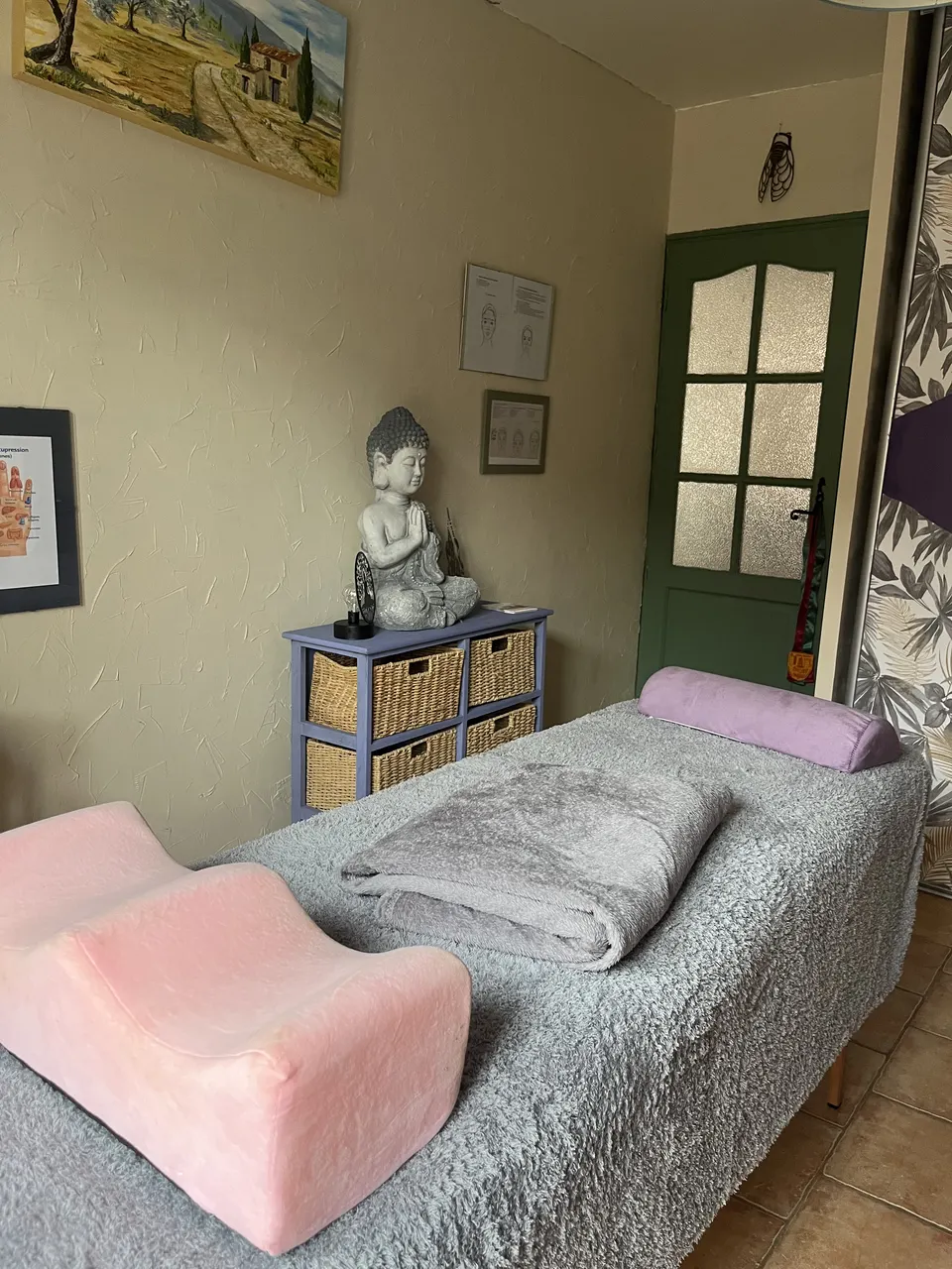 Table de soin avec plaid gris, coussin mauve et statuette Buddha